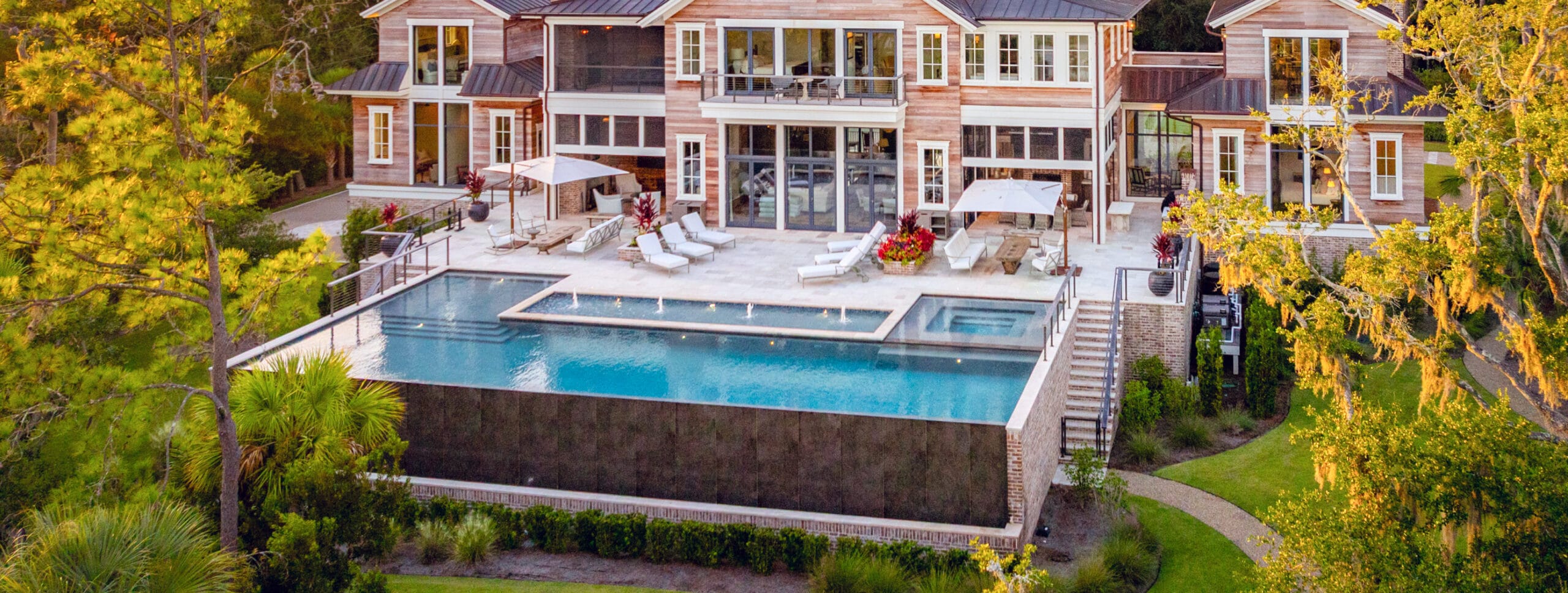 Infinity pool & spa with fountains in Charleston backyard.