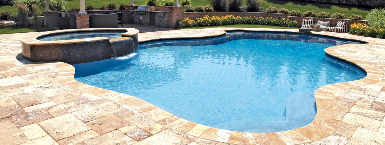 Freeform pool and spa with stone deck in Chester County.