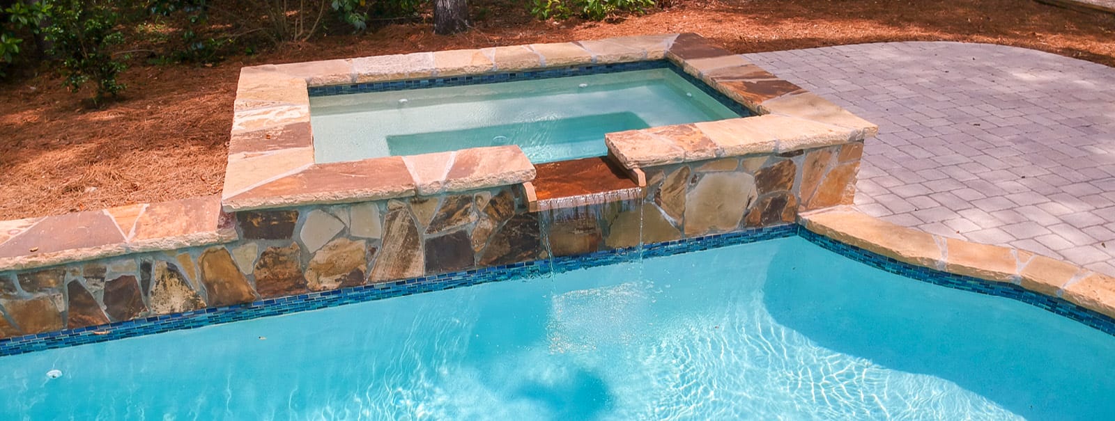 Nsples gunite pool with elevated square spa.