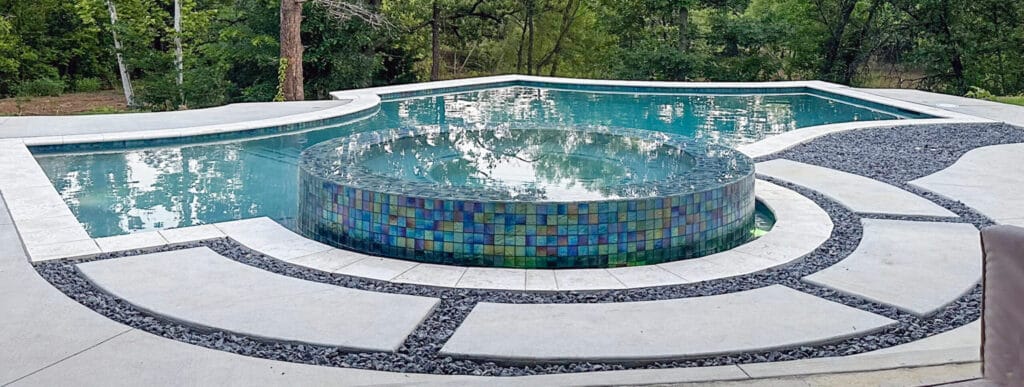 Geometric pool with perimeter-overflow spa in OKC backyard.