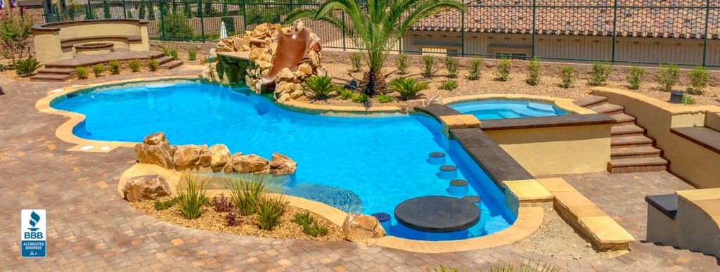 Lagoon-style custom pool with rock waterfall, swim-up bar, and beach entry.
