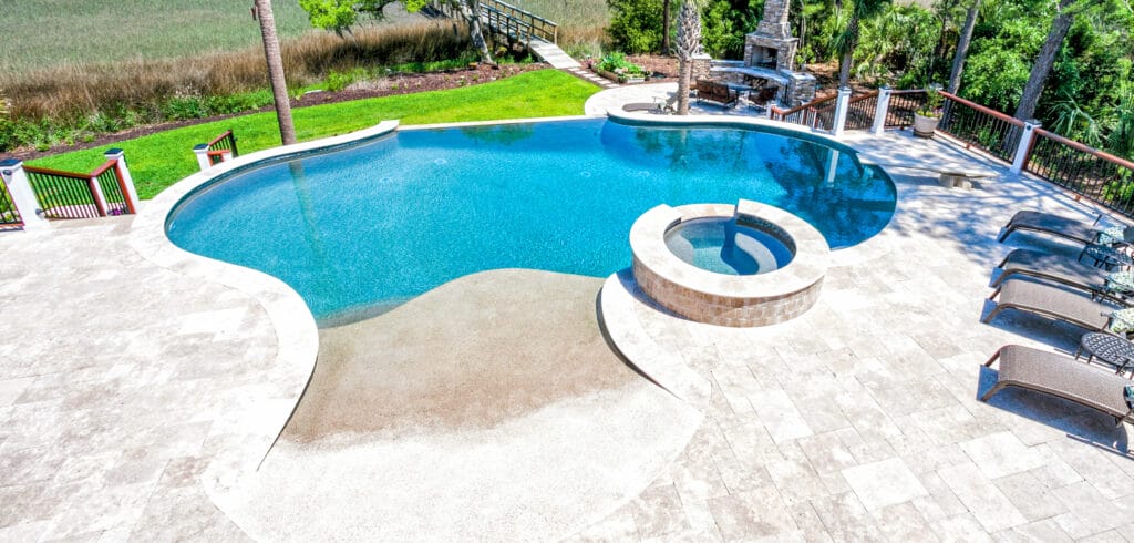 Curvy pool with round spa, vanishing edge, and beach entry.