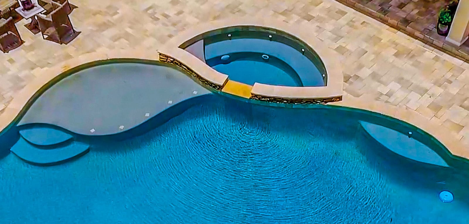 Gunite pool with a half-moon spa and curvy steps.