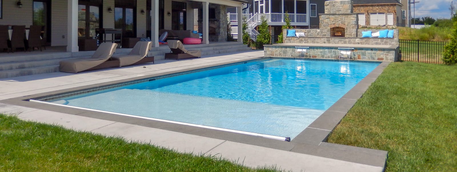Rectangle pool with automatic pool cover, tanning ledge, and two cascade water features in Calvert County.
