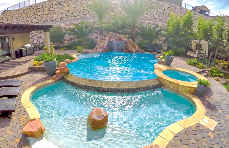 Lagoon-style Laughlin swimming pool with palm trees and accent boulders.