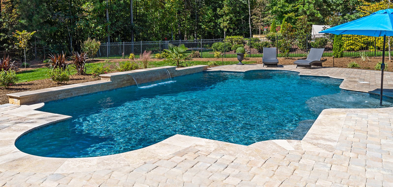 Pool built with a modified Roman shape surrounded by paver decking.