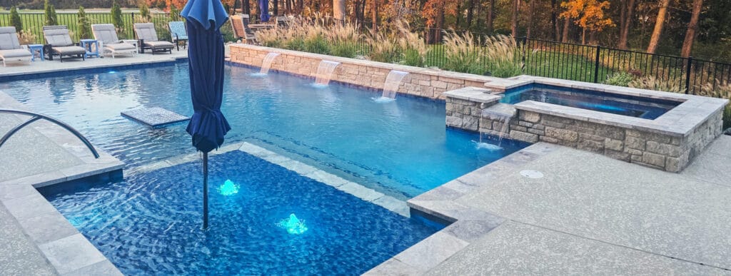 Rectangular swimming pool with large sun ledge and rectangle spa.