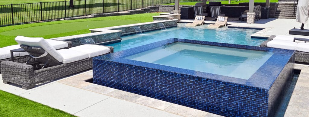 Custom pool with tiled perimeter overflow spa. in Missouri backyard.