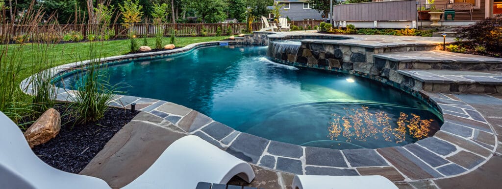 Free-form inground pool at night in Vienna, Virginia.