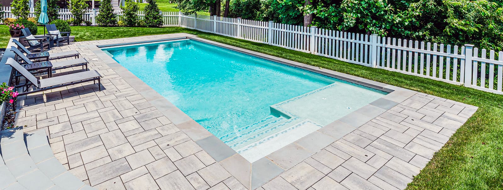 Rectangular gunite pool with tile-accented entry steps and tanning ledge in Loudon County.