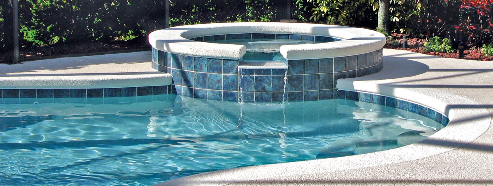 Round spa on gunite pool with concrete deck in Naples.