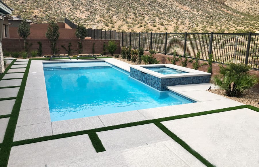 Henderson custom pool with square raised spa in backyard.