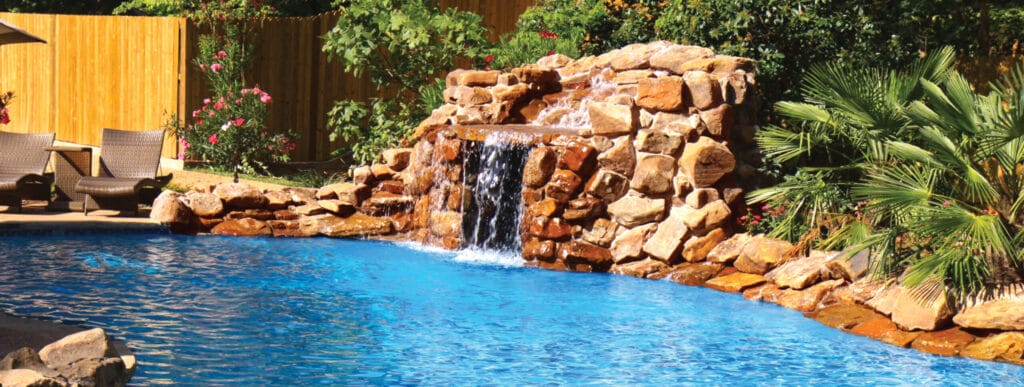 Stone grotto waterfall on custom swimming pool.