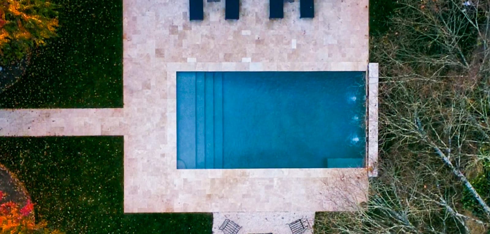 Overhead view of a rectangular pool with water features.
