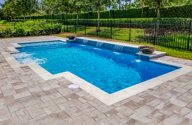modified rectangle inground pool with large cascade waterfall and tanning ledge