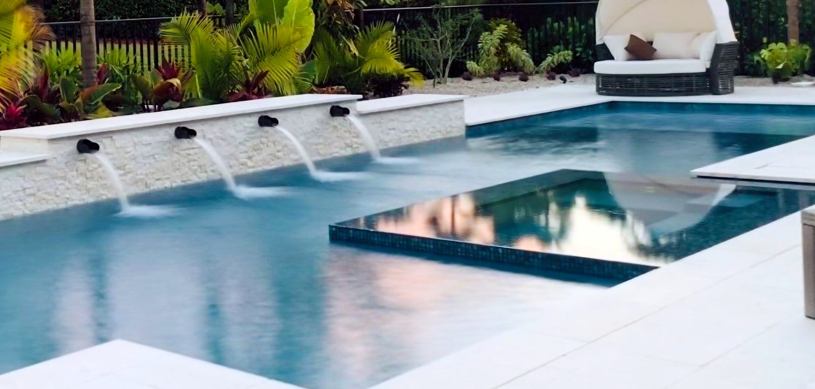 Gunite pool with spouting water features and overflow spa.