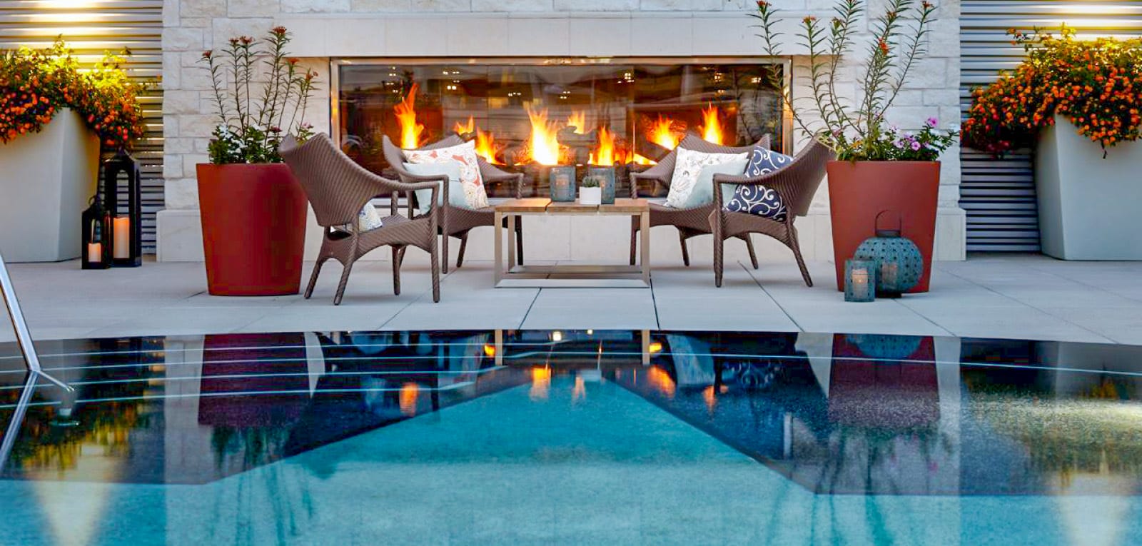 Outdoor fireplace and patio seating poolside.