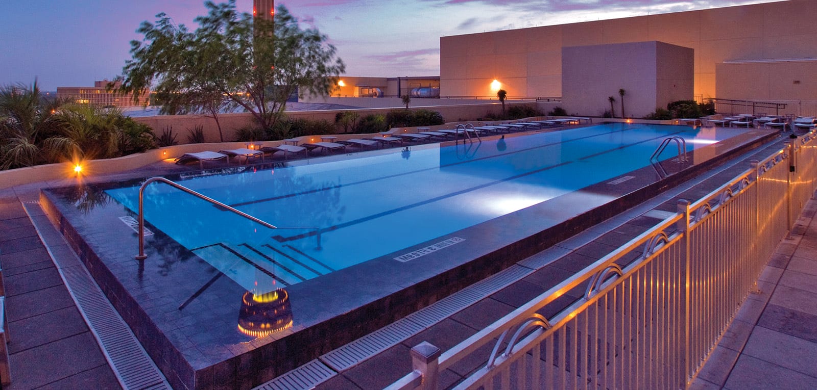 Rooftop hotel pool at sunset.