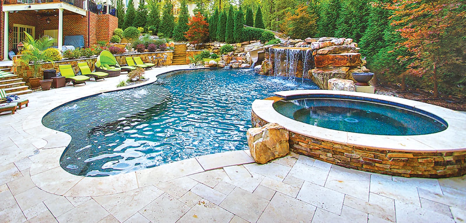 Lagoon-inspired backyard inground pool with grotto waterfall. and spa.