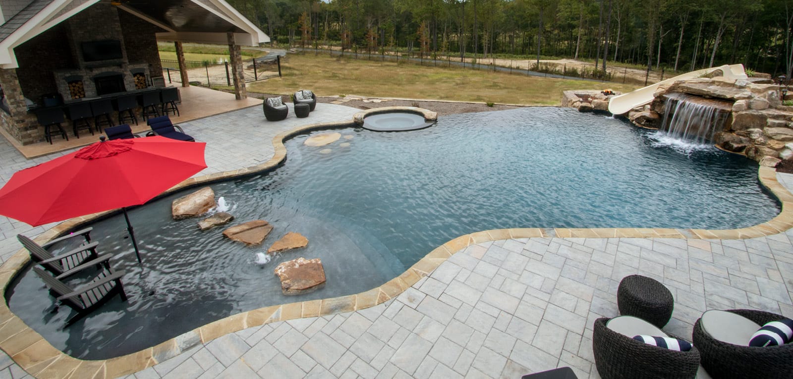 Dark, lagoon-type pool with grotto, spa, tanning ledge, and stone steps.