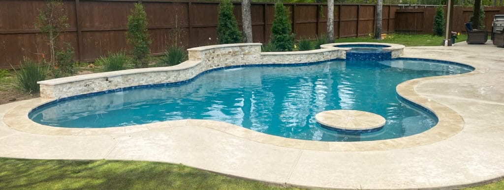 Gunite pool in Friendswood with swim-up cocktail table. and cascade water features.