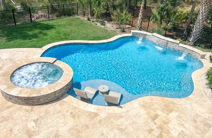 Free-form gunite pool with spa and tanning ledge