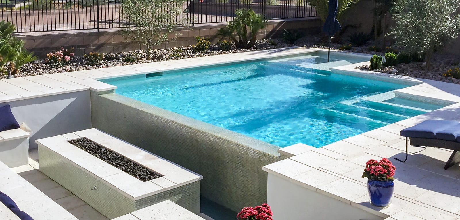 Modern geometric gunite pools with an adjacent fire pit and seating area.
