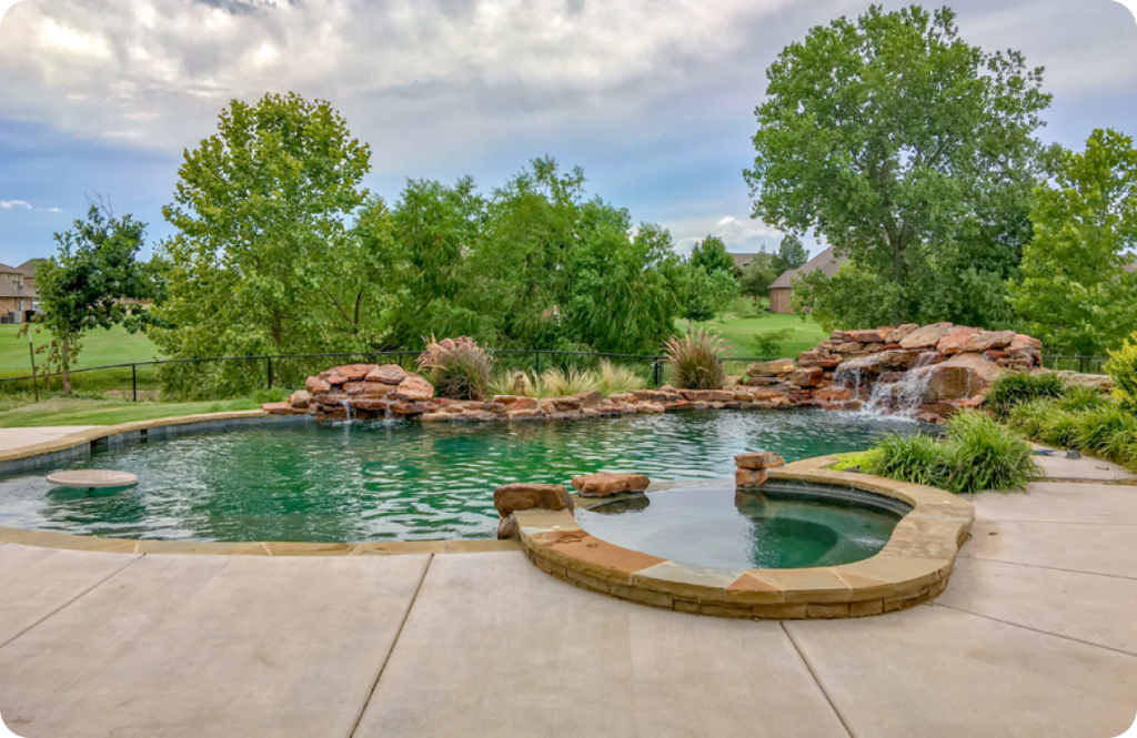 Organic-style inground pools with two rock waterfalls, spa, and accent boulders.