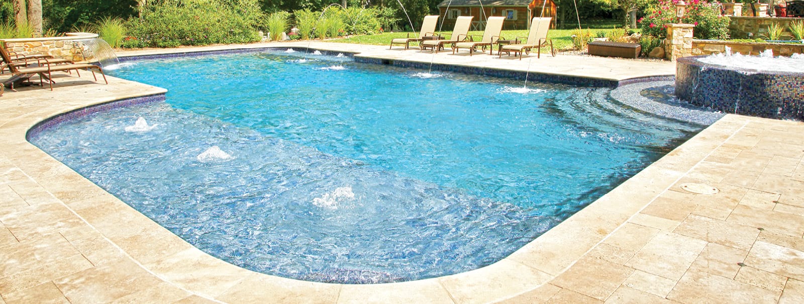 Custom swimming pool with bubbling spa and laminar water features.