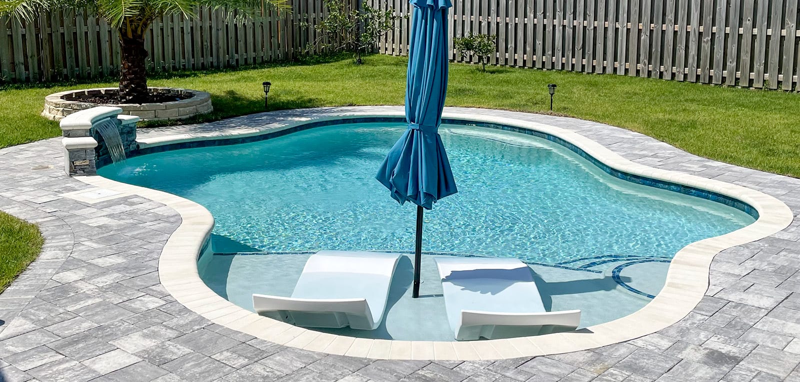 Cloud-shaped inground pool with tanning ledge.
