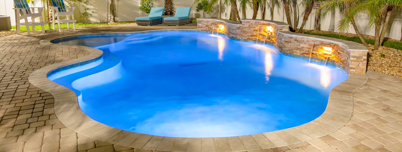 Cloud-shaped Jacksonville gunite pool at night.