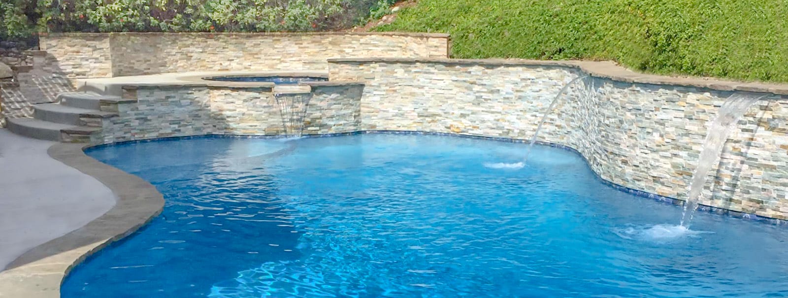 San Diego custom pool with cascade water features and ledger stone walls.