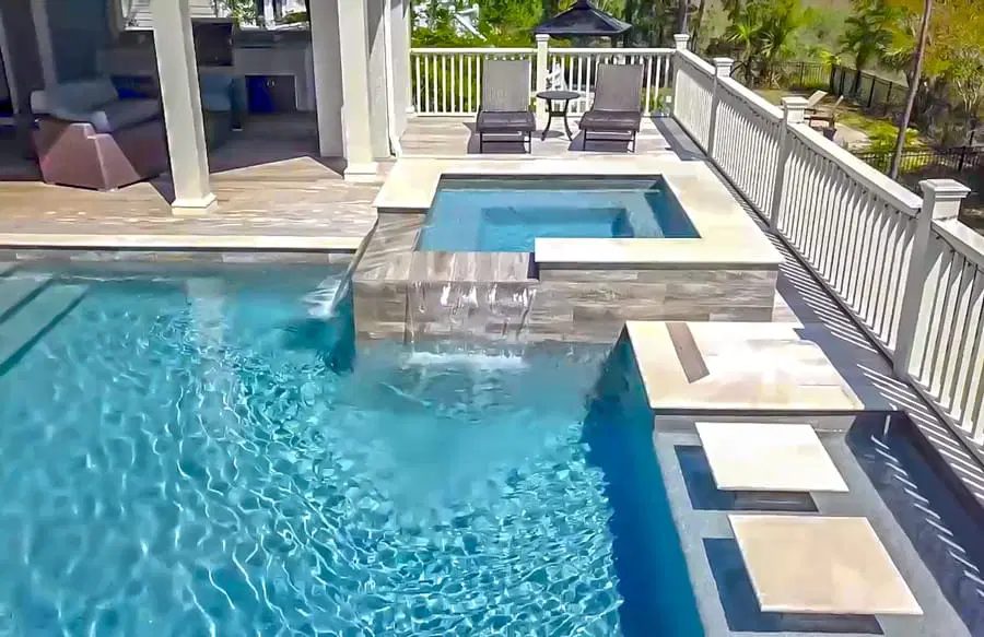 Inground pool in Bluffton with raised spa and set of steps that appear to float in the water.