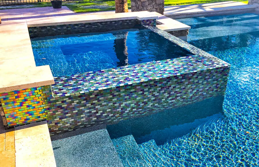 Square spa with iridescent glass tile on inground pool in Carlsbad.