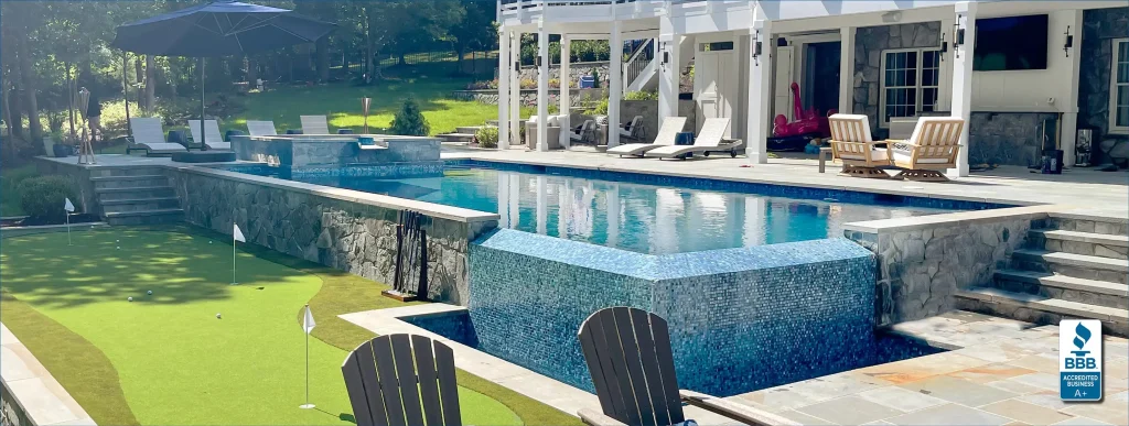 Infinity edge custom pool with mini putting green in Northern Virginia backyard.