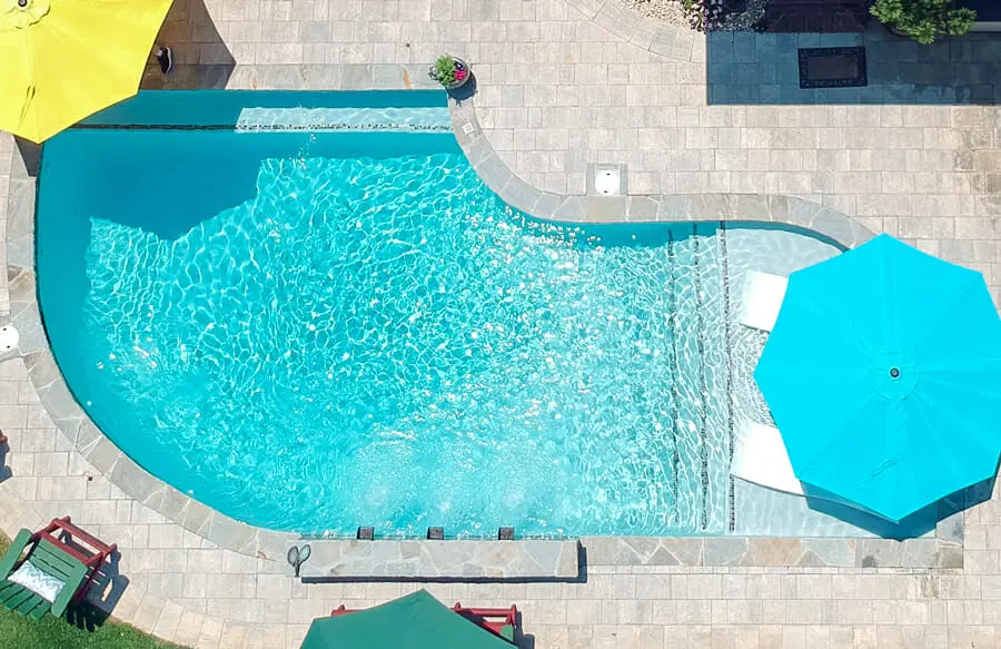 Geometric backyard pool with paverstone decking in Southeast Texas.