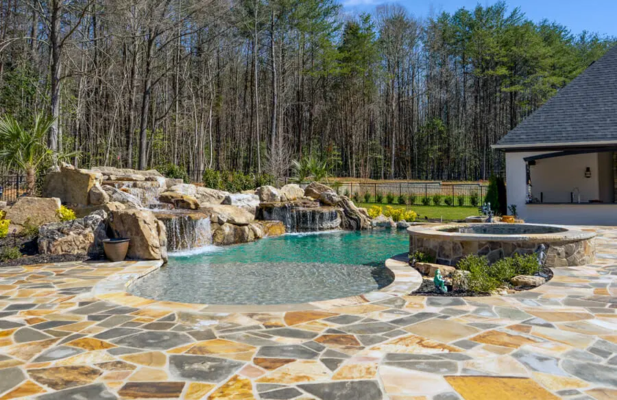 Lagoon-style pool with double-grotto stone waterfalls and flagstone deck.