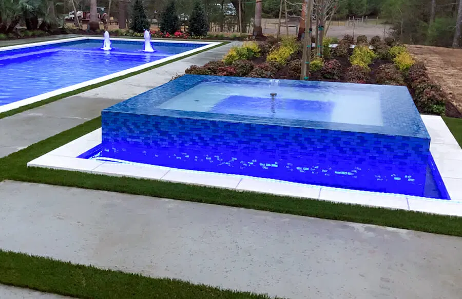 Full-perimeter overflow spa on custom Fort Worth pool.