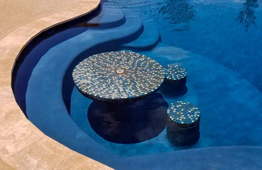 Tiled swim-up table and stools inside a Texas custom pool.