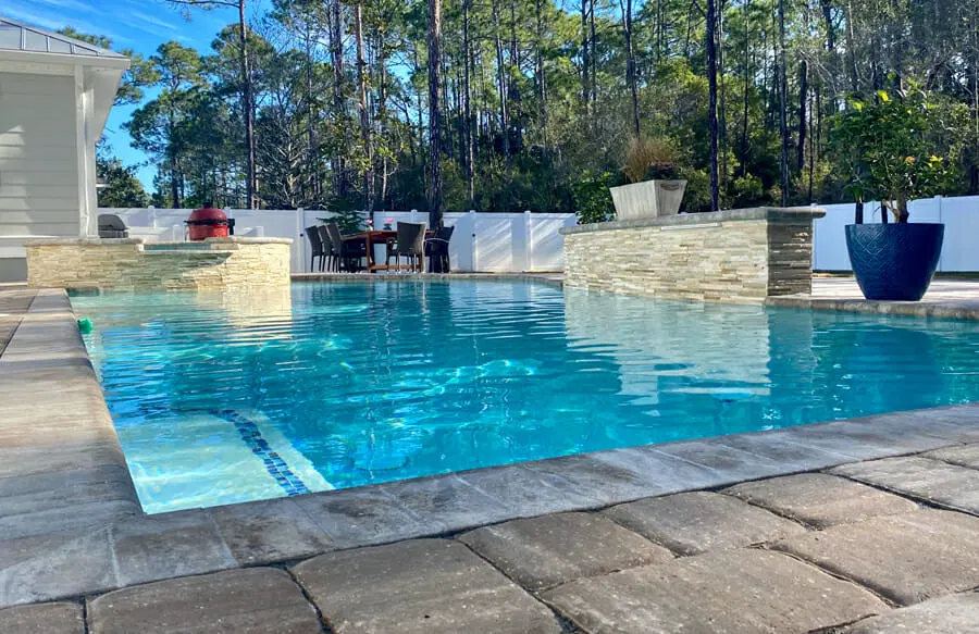 Rectangular pool with raised bond beam water feature in Pensacola.