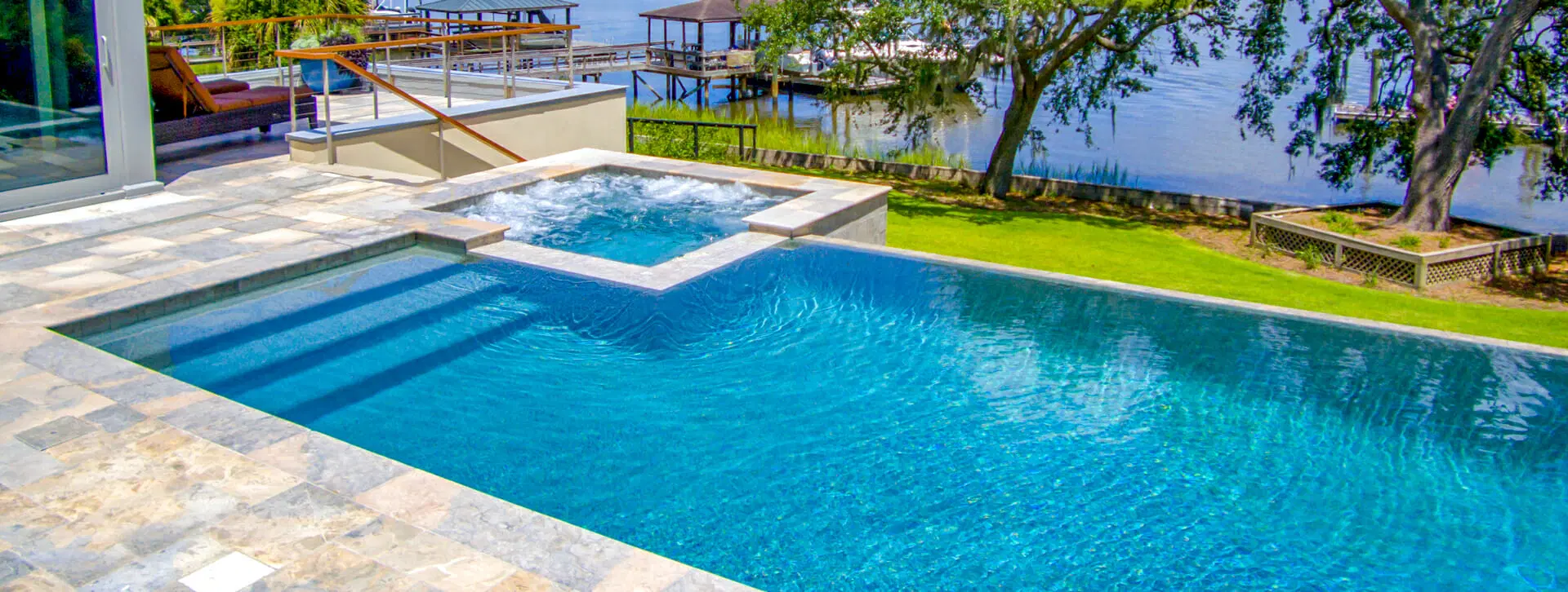 Rectangle gunite pool & spa overlooking pier and bay.