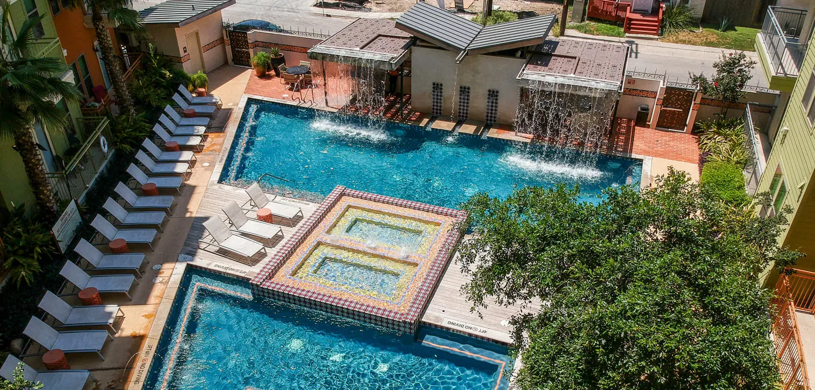 Two large connected angular swimming pools at a hotel.