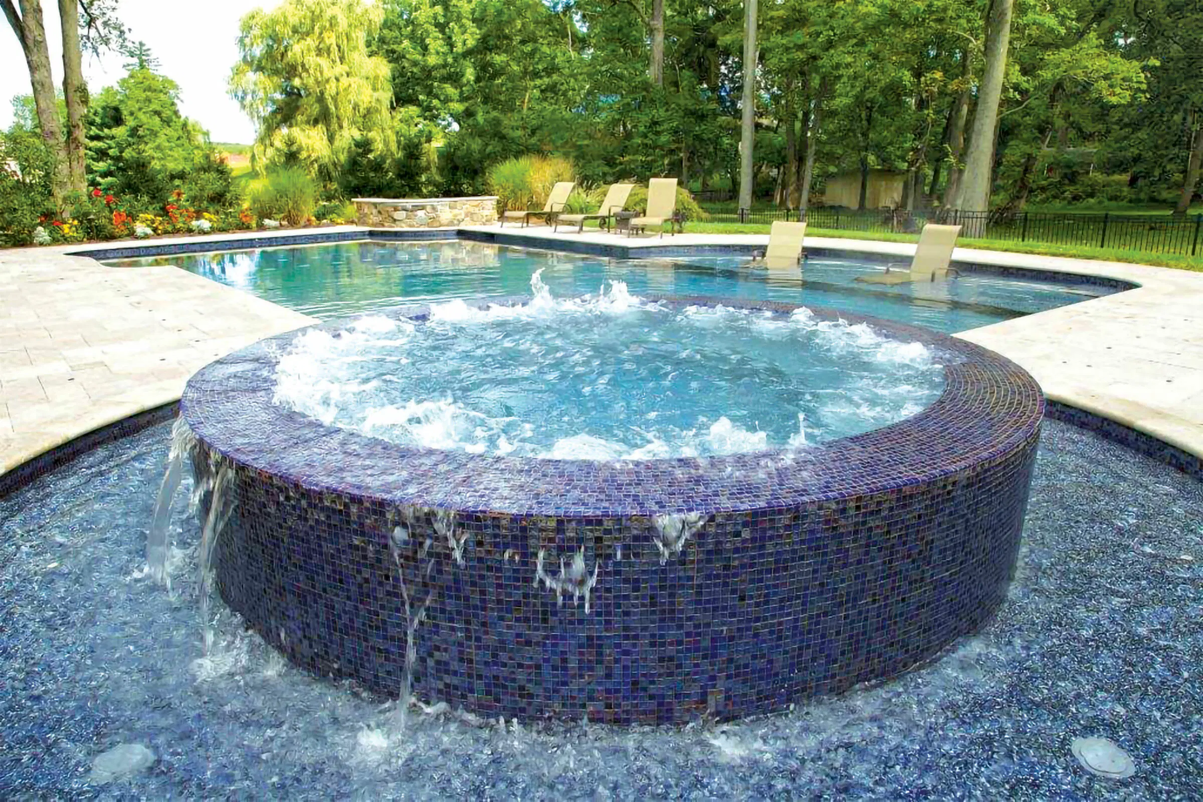Full-perimeter overflow spa on swimming pool.