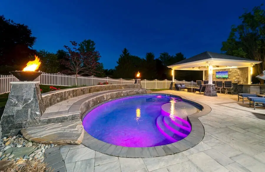 Alexandria swimming pool at night illuminated in pink and blue.