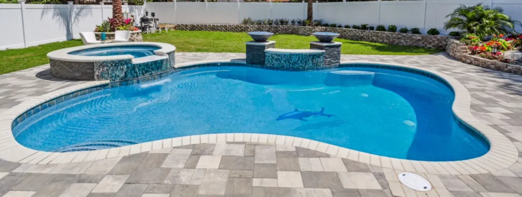 Curvy pool in Sarasota with dolphin mosaic in pool floor.