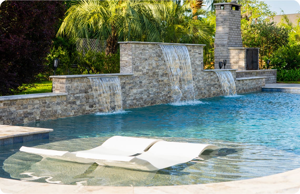 Custom pool with three cascade water features and large tanning ledge.