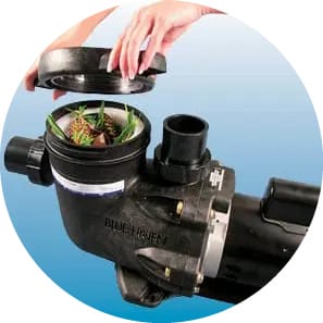 Hands unscrewing the clear top of the pump's strainer basket.