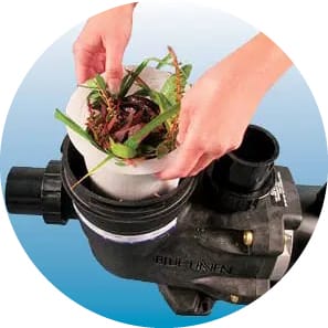 Hands lifting out the strainer basket from the pool pump.