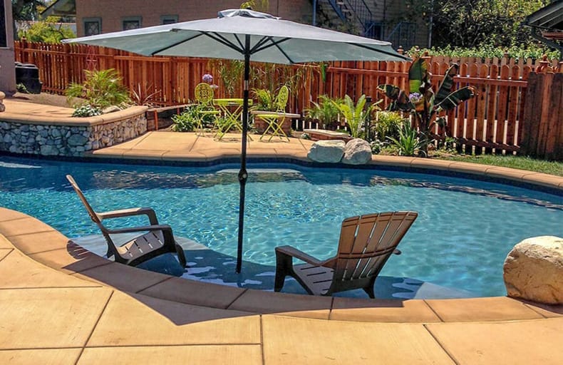 Tanning ledge with integrated umbrella on gunite pool.