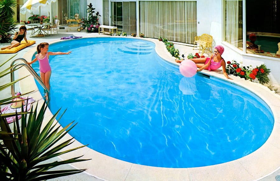 1960s-era little girl and woman playing inside kidney swimming pool.